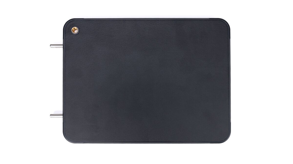 Dark rectangular metal box with rounded corners and two protruding metal posts on the left side.