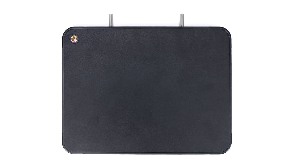 Rectangular dark leather panel with rounded corners, two metal prongs at the top, and a small brass screw in the top-left corner.