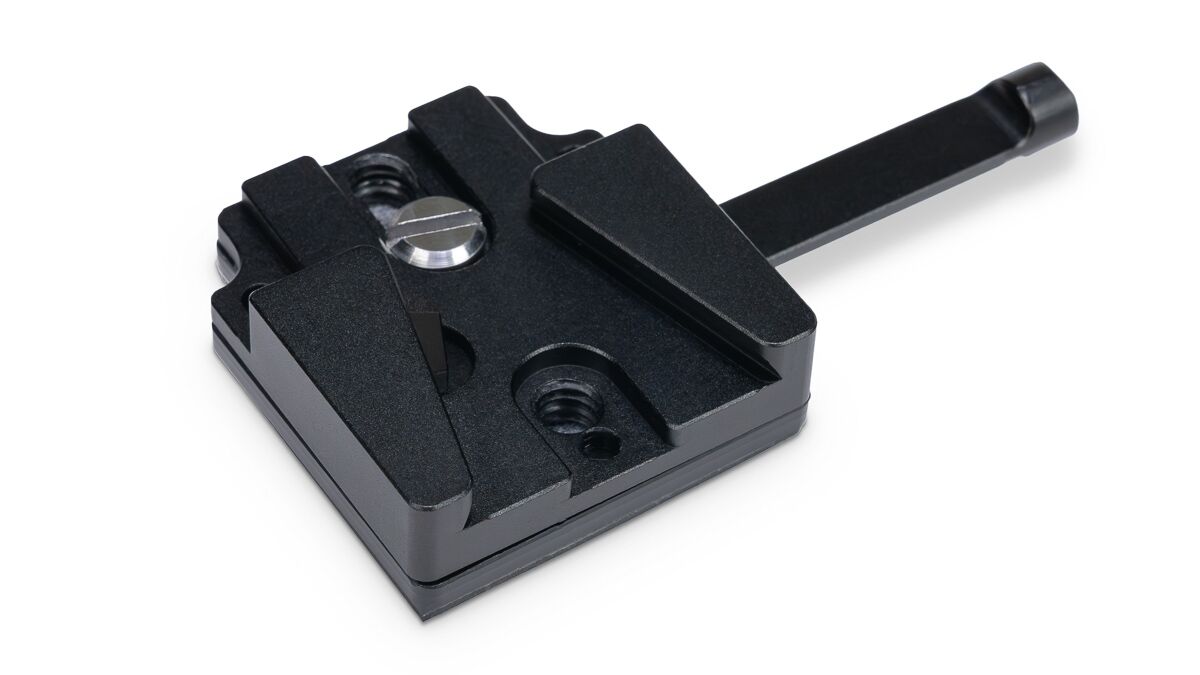 Black metal quick-release clamp with adjustable jaws and a long lever, used to secure parts in a jig or fixture in a workshop.