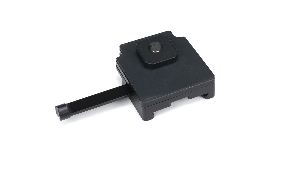 Black square camera quick-release plate with a sliding lever on a white background.