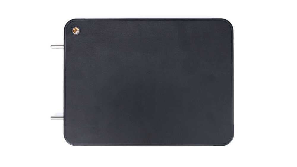 Dark rectangular metal box with rounded corners and two protruding metal posts on the left side.