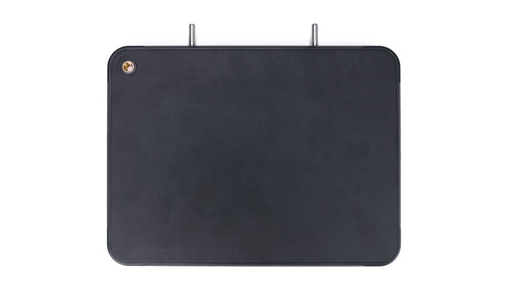 Rectangular dark leather panel with rounded corners, two metal prongs at the top, and a small brass screw in the top-left corner.