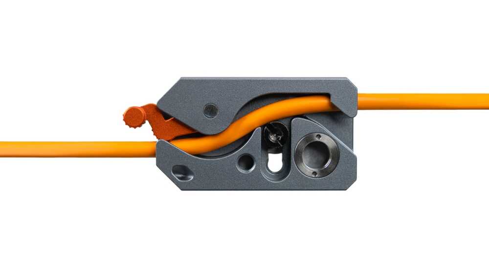 Close-up of a gray wire stripper clamping an orange electrical cable, ready to strip insulation.