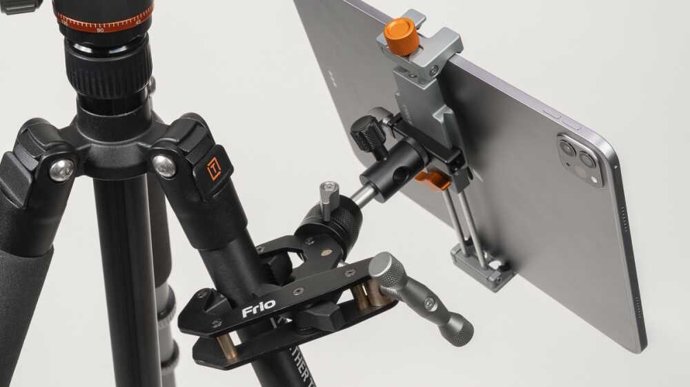Tripod with a smartphone mounted in an adjustable clamp on a horizontal arm for stable filming/photo setup