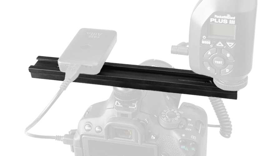 DSLR camera mounted on a horizontal rail with a PocketWizard Plus wireless trigger plugged in.