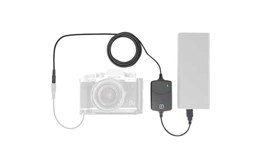 Camera connected to an external battery pack via a power adapter and cable, powering the camera setup