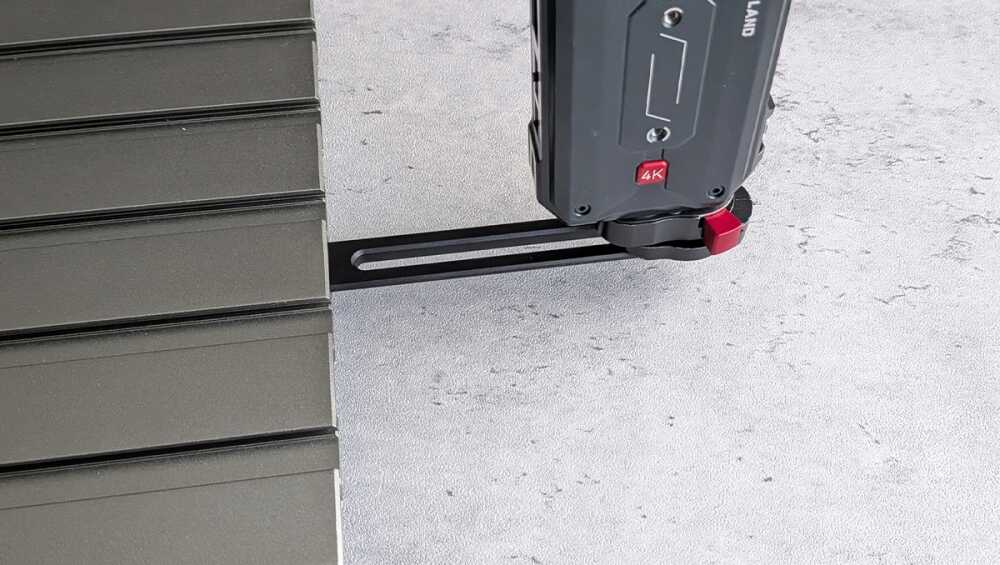 Close-up of a black linear rail mounted to a gray work surface with a tool head labeled 4K on the right.