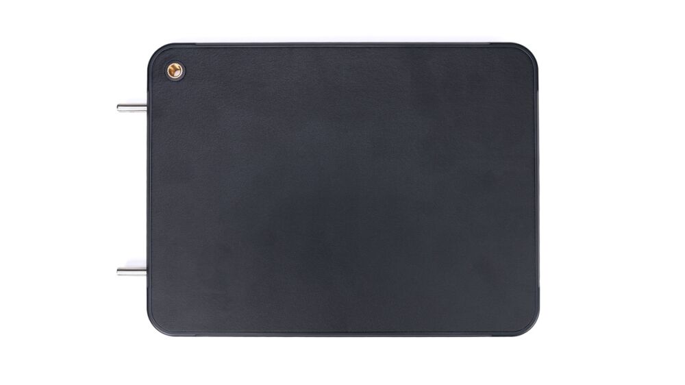 Dark rectangular metal box with rounded corners and two protruding metal posts on the left side.
