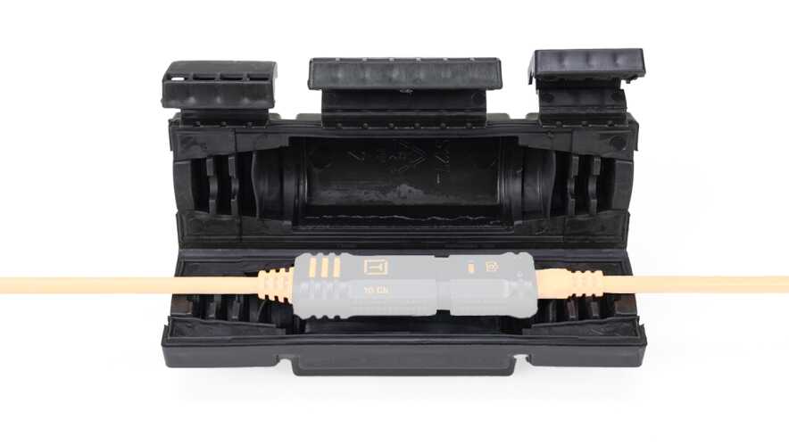 Orange fiber optic cable plugged into a gray 10 Gb connector resting in a black protective case.